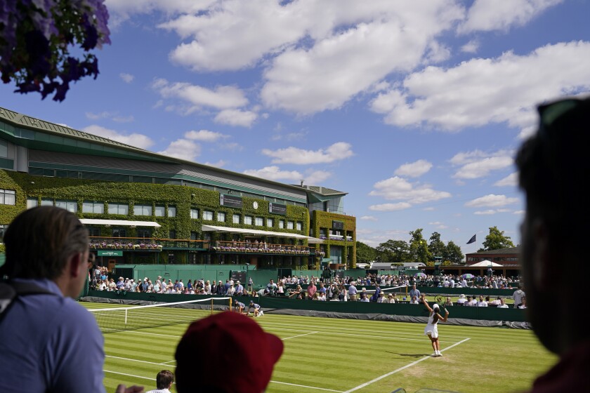 Spectators watch as Italy's Georgia Pedone serves during a Girls singles match on day eight of the Wimbledon tennis championships in London, Monday, July 4, 2022. (AP Photo/Alberto Pezzali)