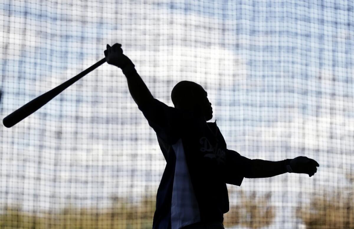 Carl Crawford, who is recovering from elbow surgery, swings a bat during spring training.