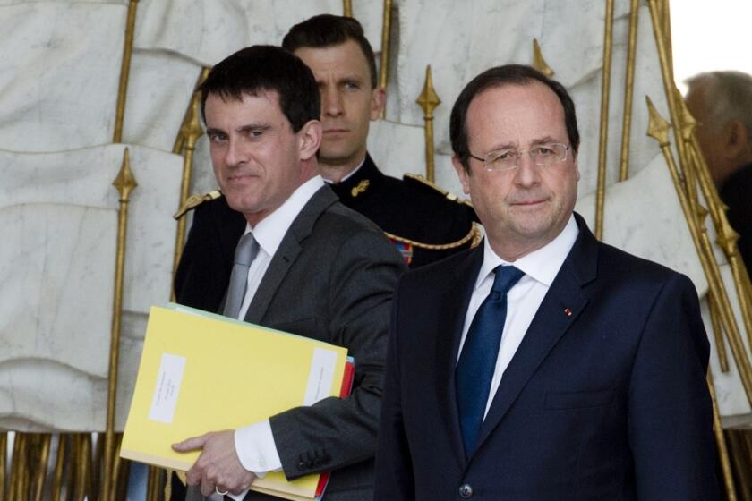 A file photo taken March 19 shows French Interior Minister Manuel Valls, left, and President Francois Hollande, right, leaving the Elysee Palace in Paris after the weekly cabinet meeting. Hollande named Valls as the nation's new prime minister on Monday.
