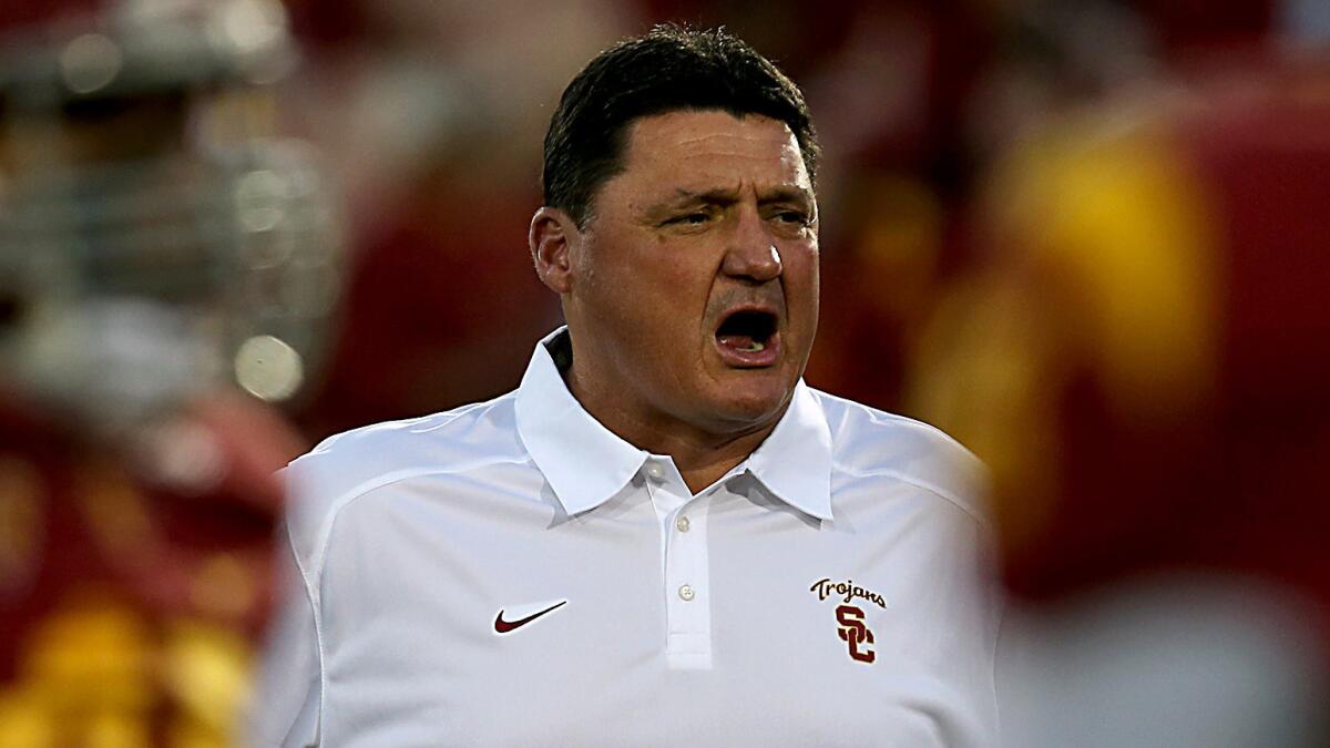 Ed Orgeron watches USC players warm up before a game against UCLA at the Coliseum on Nov. 30, 2013.