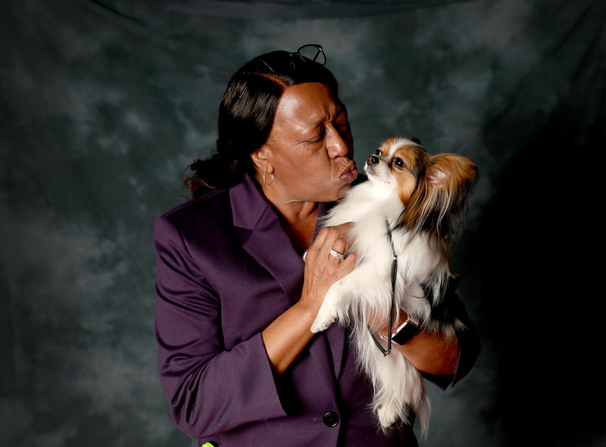 Staci Thompson, 61, of Long Beach, poses with Ari, a 13-month-old papillon. 