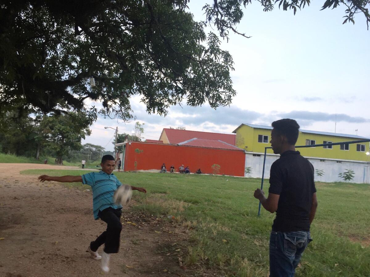 Wilmer Mauricio Lopez, 19, right, and Christian Rauldales, 24, play soccer outside a migrant shelter in Tenosique, Mexico, while they wait for the arrival of the train they will try to ride north to the U.S.