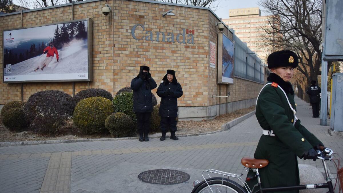 Chinese police stand guard outside the Canadian Embassy in Beijing on Monday.