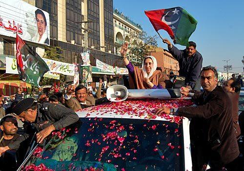 Former Pakistani Prime Minister Benazir Bhutto waves as she arrives in Rawalpindi to address her last public rally. She was assassinated just after the rally ended.