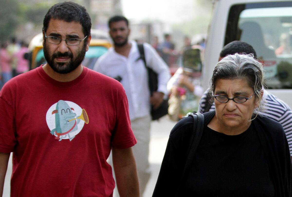 Egypt's most prominent activist, Alaa Abdel Fattah, left, walks with his mother, Laila Soueif, a university professor and activist, outside a court where 23 fellow activists were sentenced to prison for staging an illegal demonstration. Among the 23 was Abdel-Fattah's sister, Sanaa Seif.