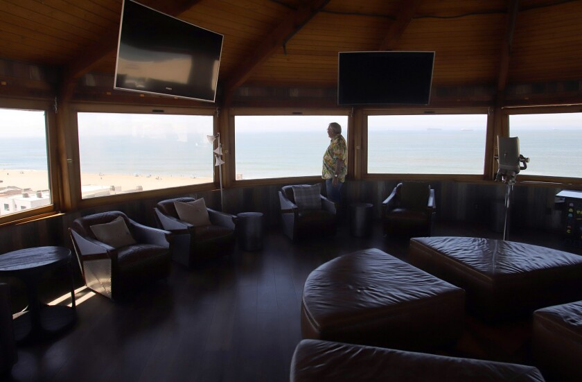 Dr. Gregg DeNicola stands in the top lounge room with a 360-degree view of the ocean.