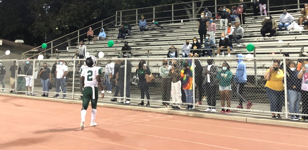 Dorsey quarterback Josh Coleman talks to fans in the stands at Jackie Robinson Stadium.
