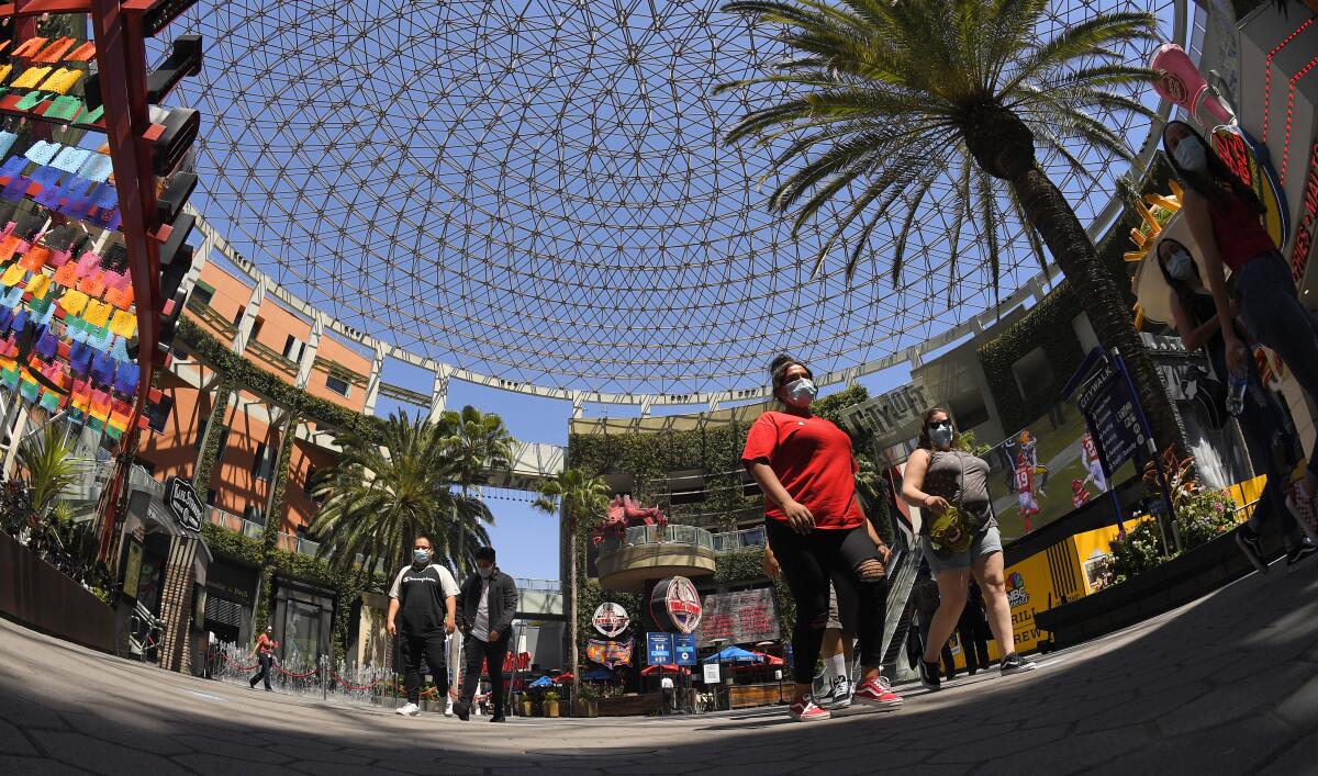 Varias personas recorren el paseo turístico Universal CityWalk 