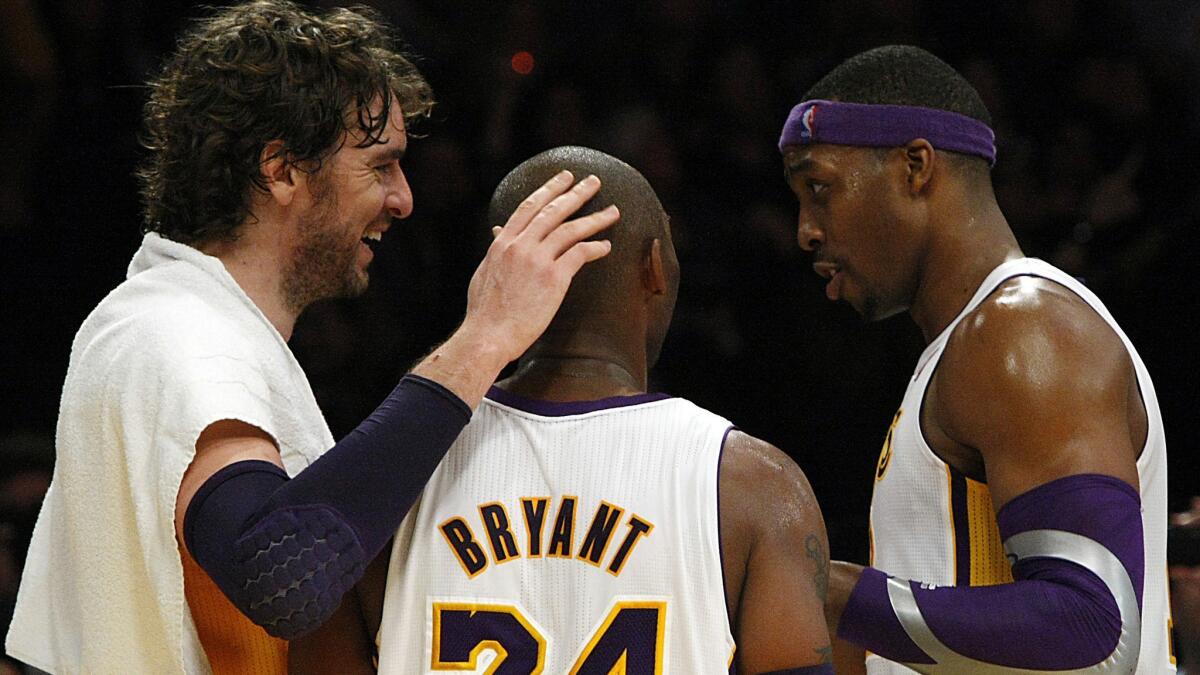Lakers teammates Pau Gasol, left, Kobe Bryant and Dwight Howard celebrate in the closing moments of their 119-108 victory over the Houston Rockets on Nov. 18, 2012.