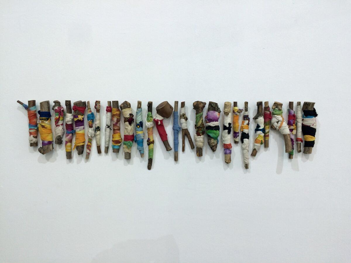 Twigs are carefully wrapped in colorful rags in the John Outterbridge piece "Ragged Bar Code," from 2008.