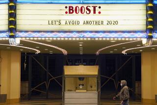 A man walks underneath the marquee of the Alex Theatre in Glendale, Calif., in January.