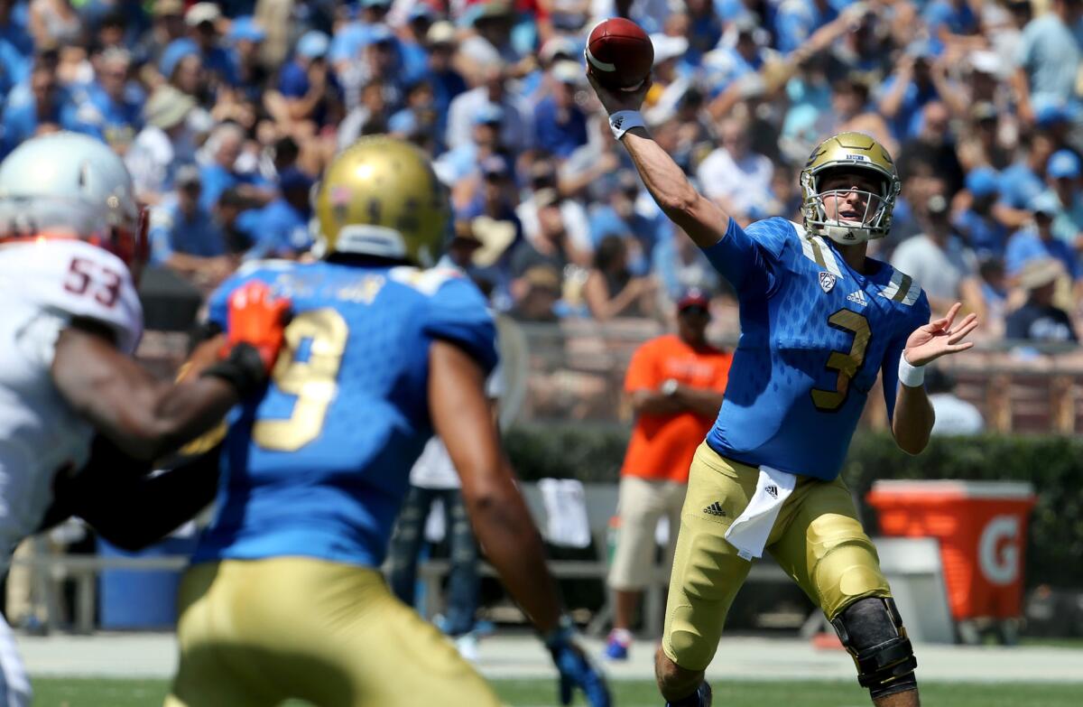 Bruins quarterback Josh Rosen takes aim for receiver Jordan Payton (9), who is covered by Cavaliers linebacker Micah Kiser (53) in the first half.