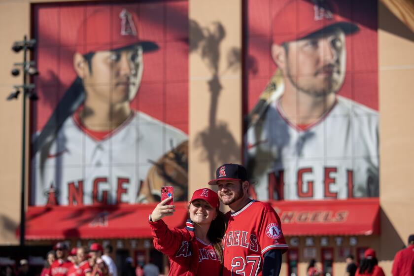 ANAHEIM, CA - APRIL 07: Katie Rhodes, left, and Matt Guerrero, right, of Riverside, take a selfie as fans gather.