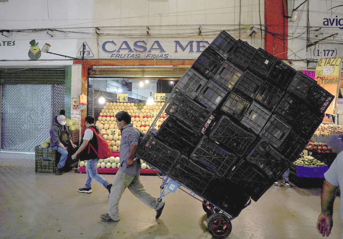 ARCHIVO - Un porteador traslada cajas de mercadería en la Central de Abastos, 