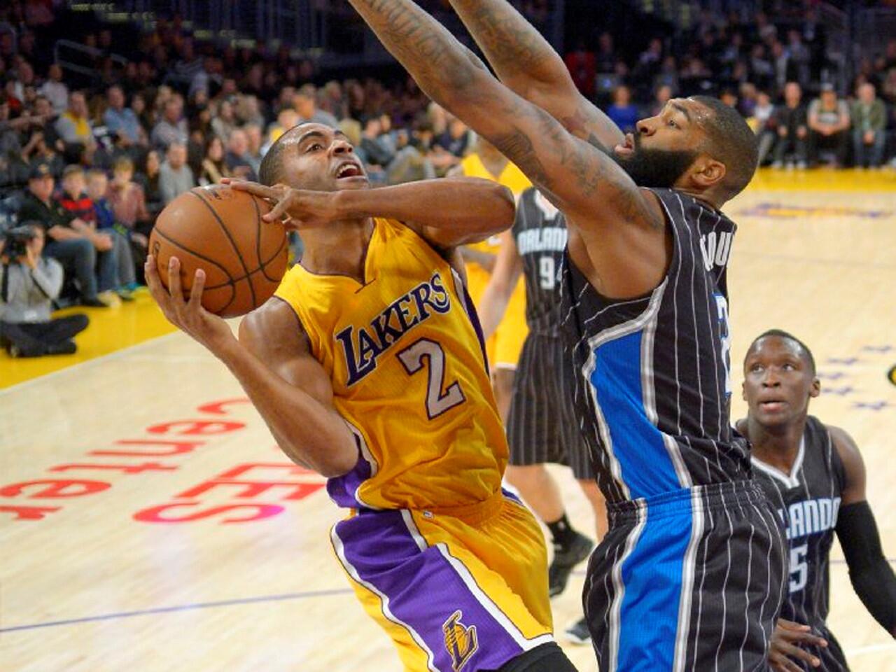 Lakers guard Wayne Ellington tries to put up a shot with Magic power forward Kyle O'Quinn standing in his way during the first half.