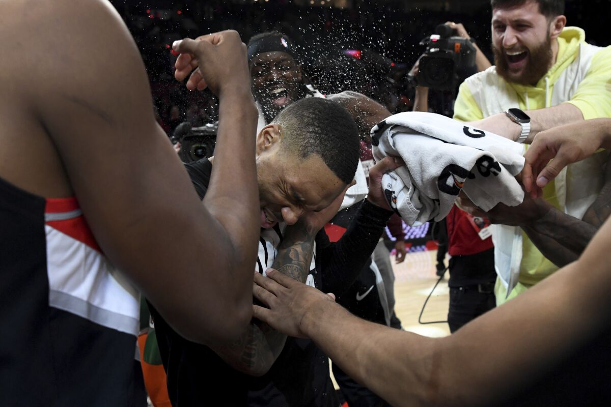 Portland Trail Blazers guard Damian Lillard, center, is doused by teammates after scoring a career-high 71 points.