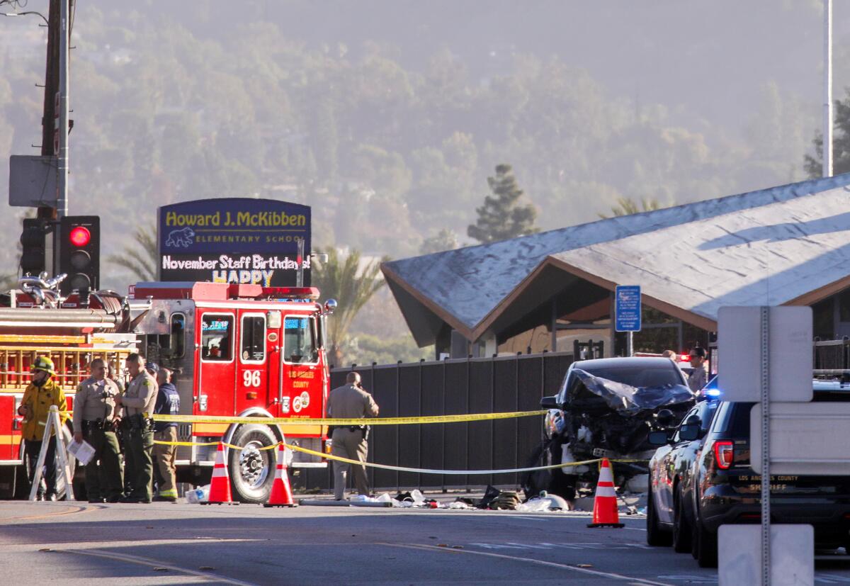 Emergency crews investigate a scene near wreckage of car 