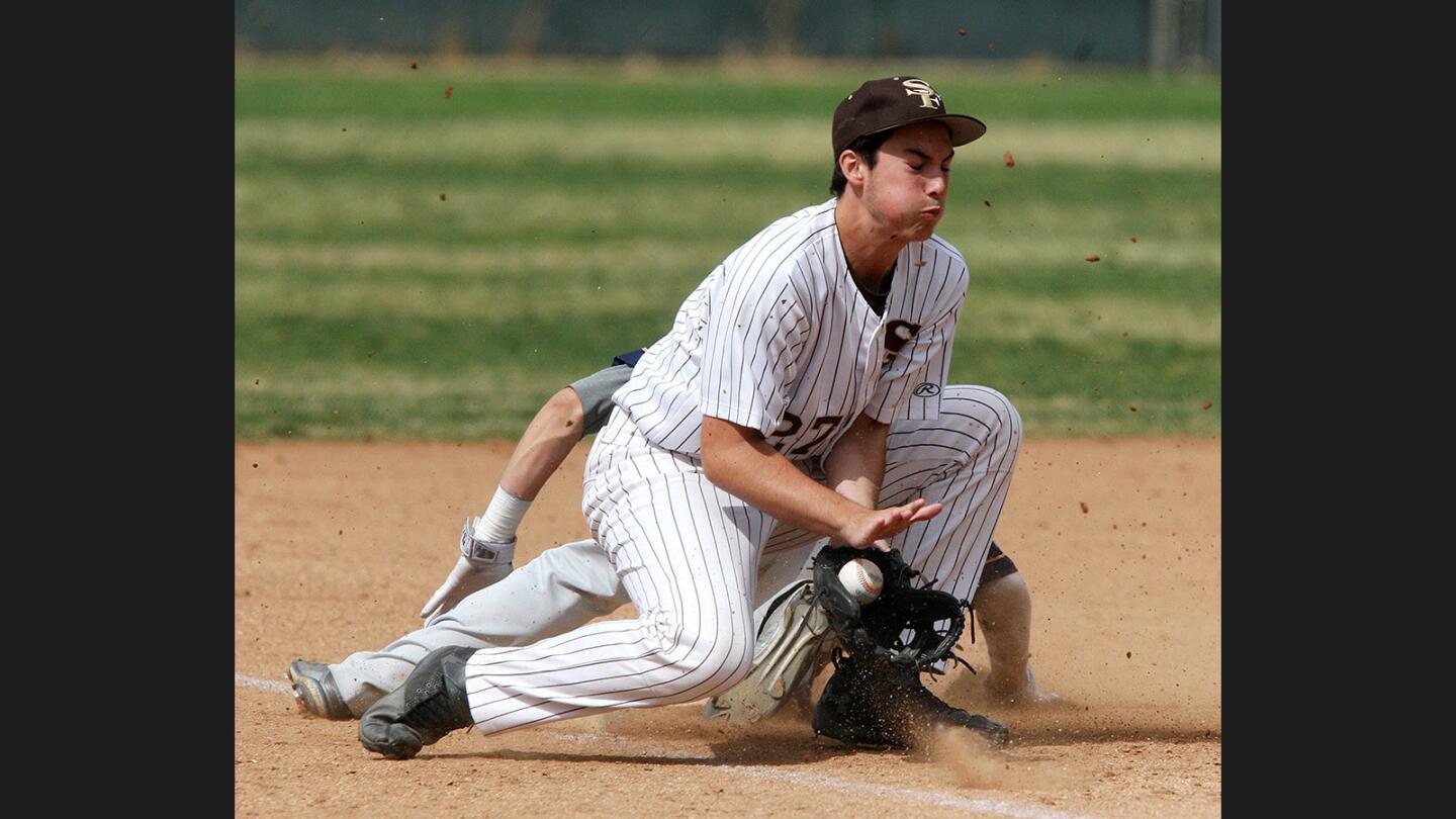 St. Francis' Aaron Treloar, at third base, gets the ball a little late as Notre Dame's Grant Berman slides in safely in a Mission League baseball game at the Glendale Sports Complex on Monday, May 8, 2017.
