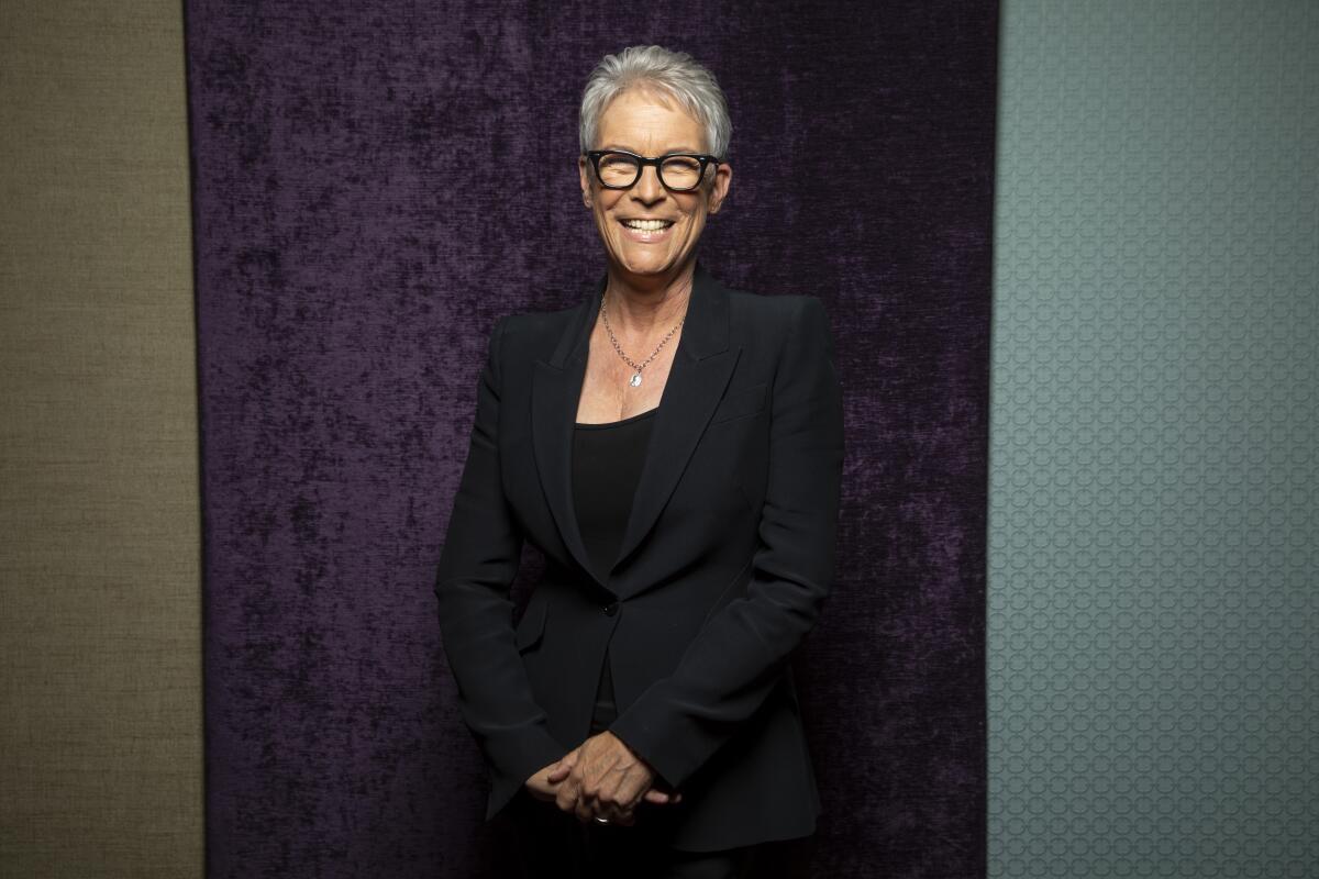 Jamie Lee Curtis smiles in a black suit.