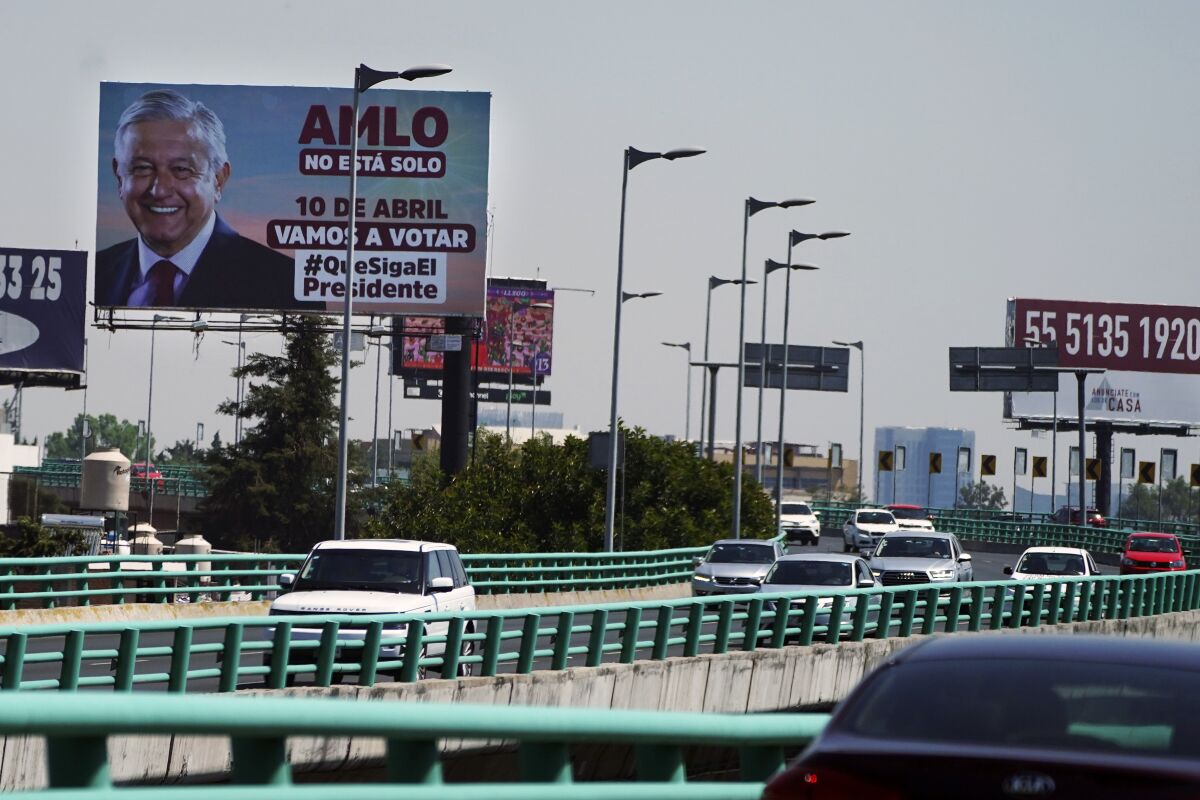 A billboard featuring Mexico's President Andres Manuel Lopez Obrador with a message encouraging citizens to get out and vote towers over a highway in Mexico City, Saturday, March 26, 2022. On April 10, a presidential recall referendum will be held to revalidate his administration after three years in office. Mexicans will be asked if they want the president to continue in office until 2024 or resign. (AP Photo/Marco Ugarte)
