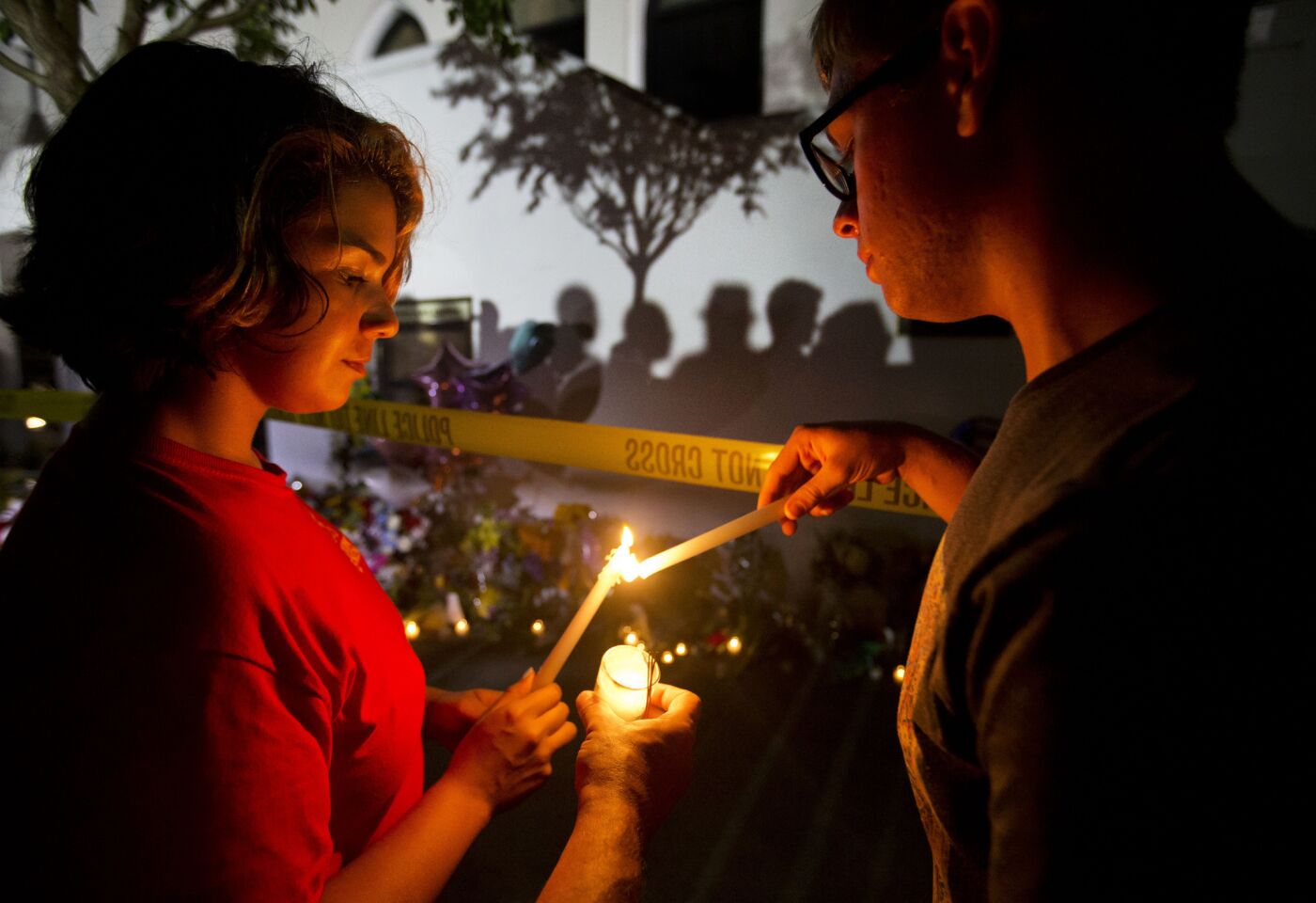 Olina Ortega, left, and Austin Gibbs light candles at a sidewalk memorial in front of Emanuel AME Church in Charleston.