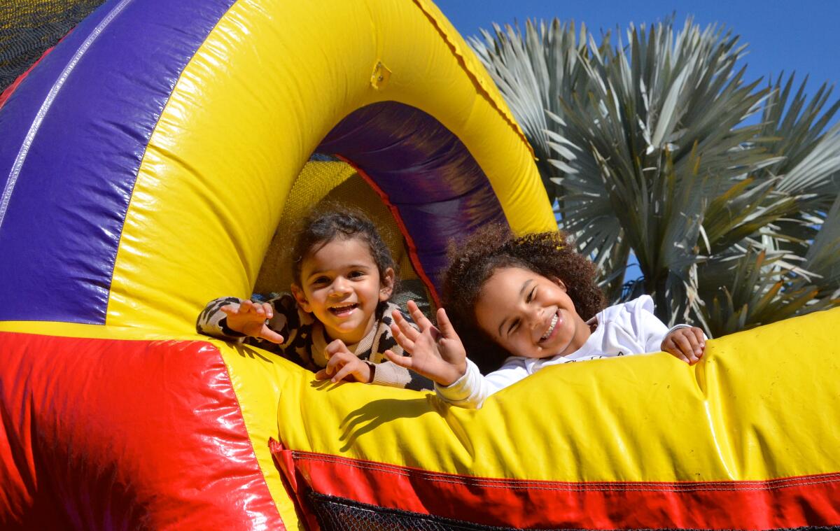 McKinney sisters Frances and Georgianna play in a bounce house at the Working Wardrobes Spring Festival.