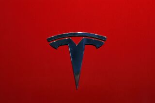 El logo de Tesla en un model 3 en una exhibición automotriz, el 3 de octubre de 2018, en París. (AP Foto/Christophe Ena, Archivo)