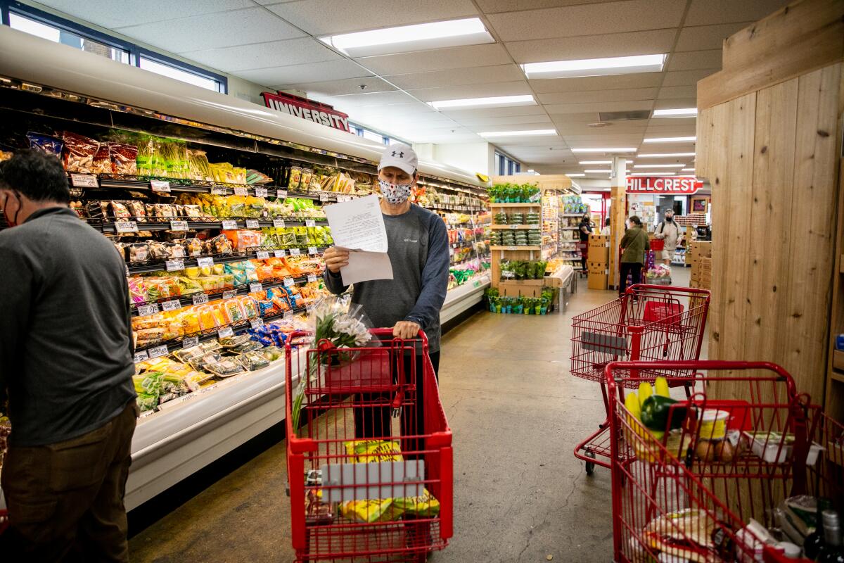 Frank Pucharski picks up groceries for Joan Schomburg, 87, at Trader Joe's in Hillcrest.