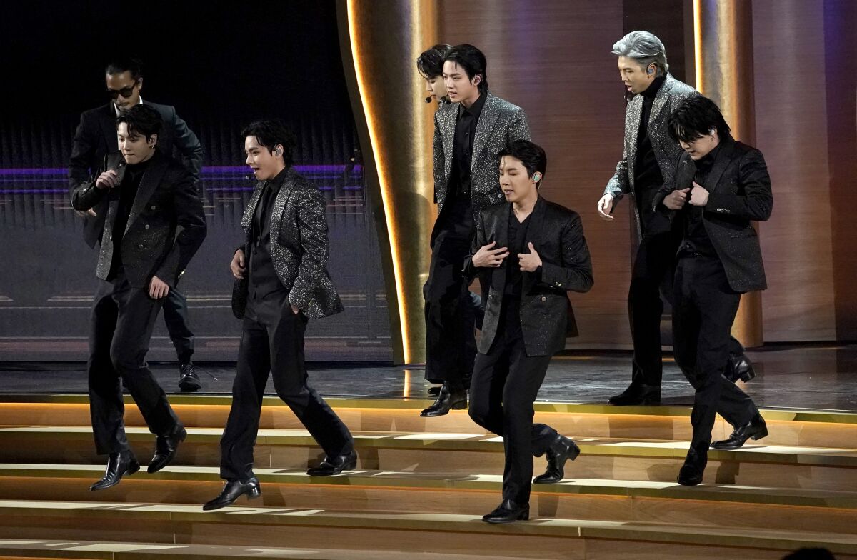 A boy band performs onstage.