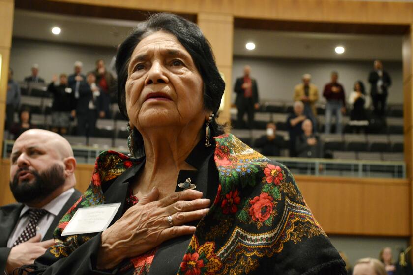 FILE - In this Feb. 27, 2019, file photo, Dolores Huerta, the Mexican-American social activist who formed a farmworkers union with Cesar Chavez, stands for the Pledge of Allegiance in Spanish while visiting the New Mexico Statehouse in Santa Fe. N.M. Huerta is endorsing Joe Biden, giving him the backing of one of the nation’s most prominent Latino leaders. (AP Photo/Russell Contreras, File)