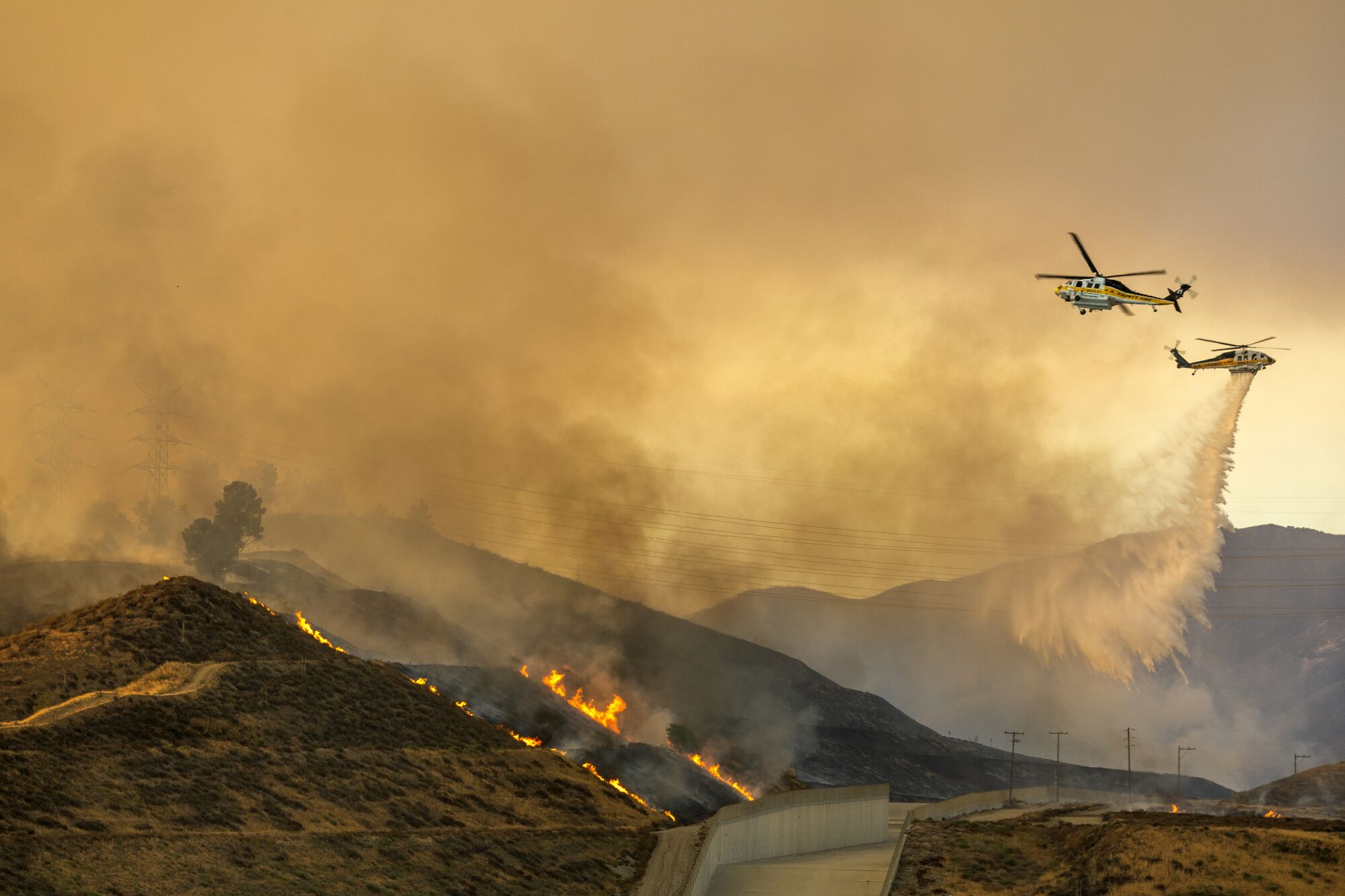 A water-dropping helicopters hovers at the Castaic Lake State Recreation Area while battling the Route fire.