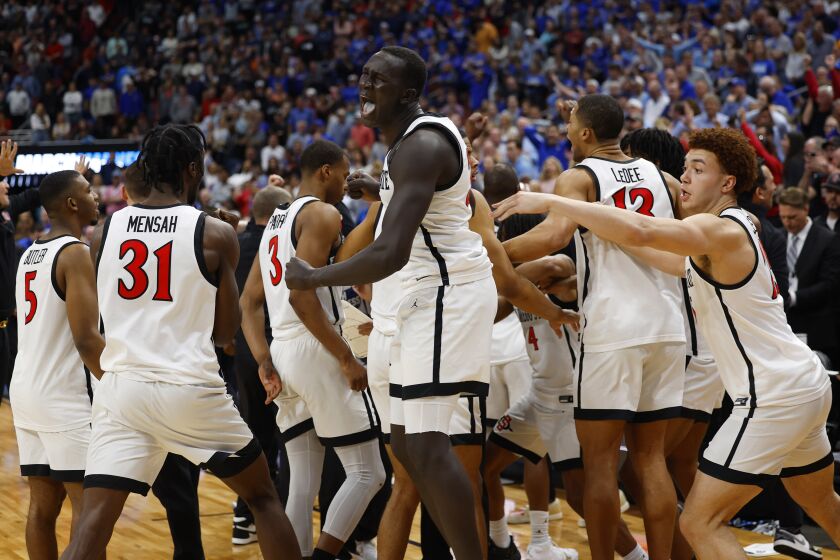 Louisville, KY - March 26: San Diego State's Aguek Arop, center, and the Aztecs celebrate after the game was over in a 57-56 victory over Creighton in an Elite 8 game in the NCAA Tournament on Sunday, March 26, 2023 in Louisville, KY. (K.C. Alfred / The San Diego Union-Tribune)