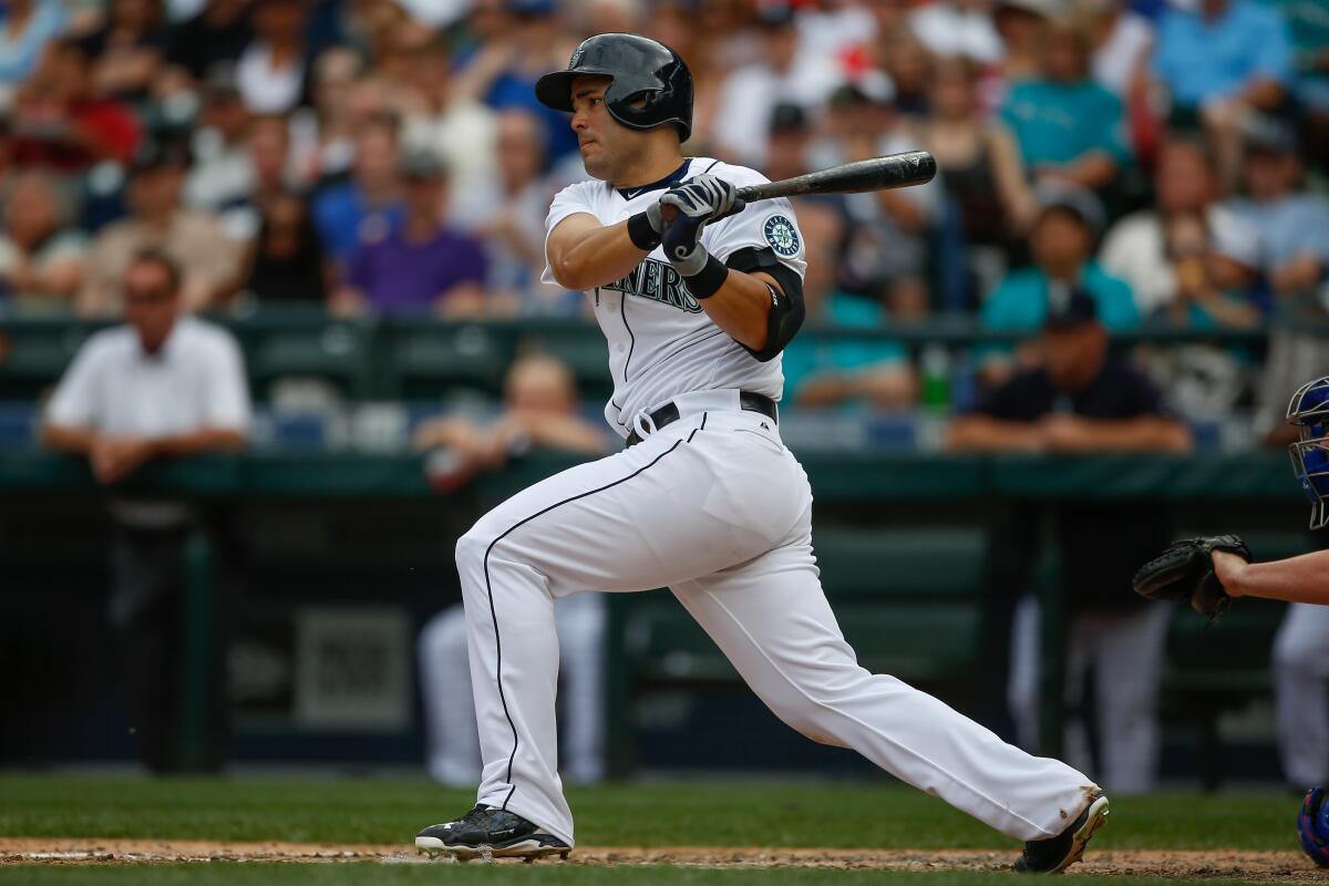 Jesus Montero finishes swinging a baseball bat in a Seattle Mariners uniform