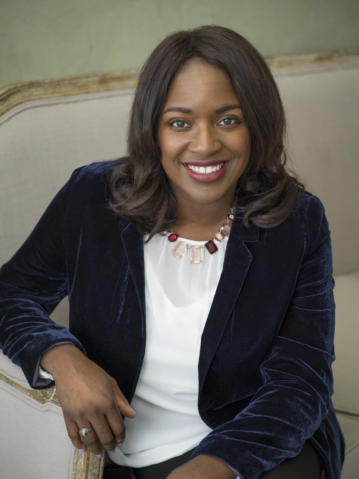 Author Nancy Johnson sits on a couch.