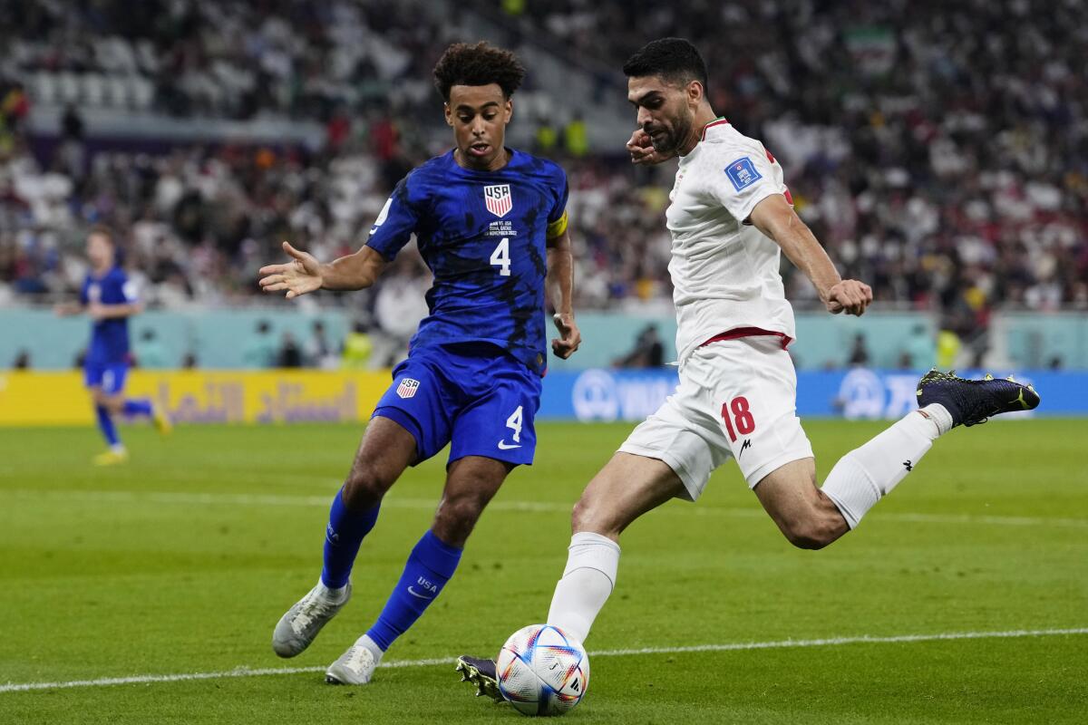 Tyler Adams of the United States, left, challenges Iran's Ali Karimi during the second half.
