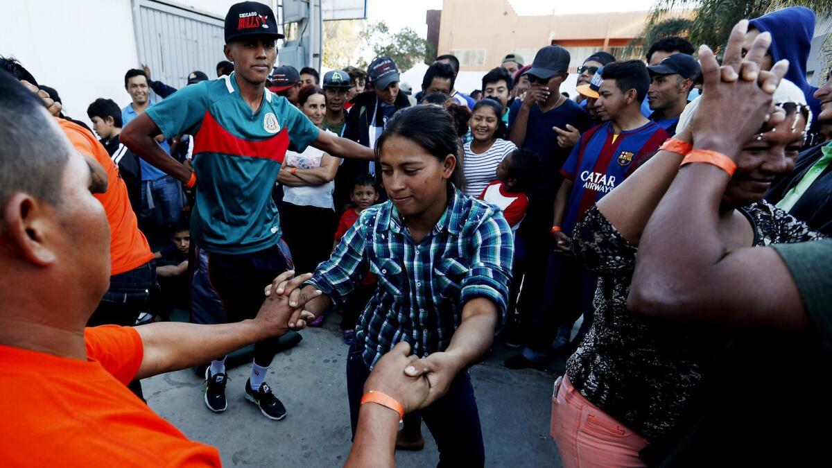 Central Americans dance inside the Benito Juarez Sports Center in Tijuana after arriving Friday.