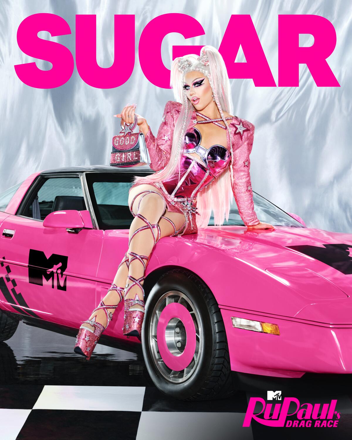 A platinum blond in a metallic pink outfit sits on a hot pink car holding a purse in one hand