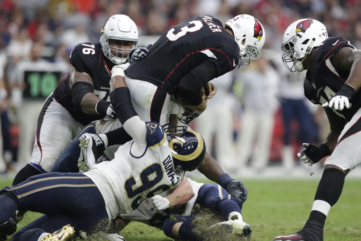 Rams defensive lineman Aaron Donald pulls down Cardinals quarterback Carson Palmer early in the fourth quarter for a sack.