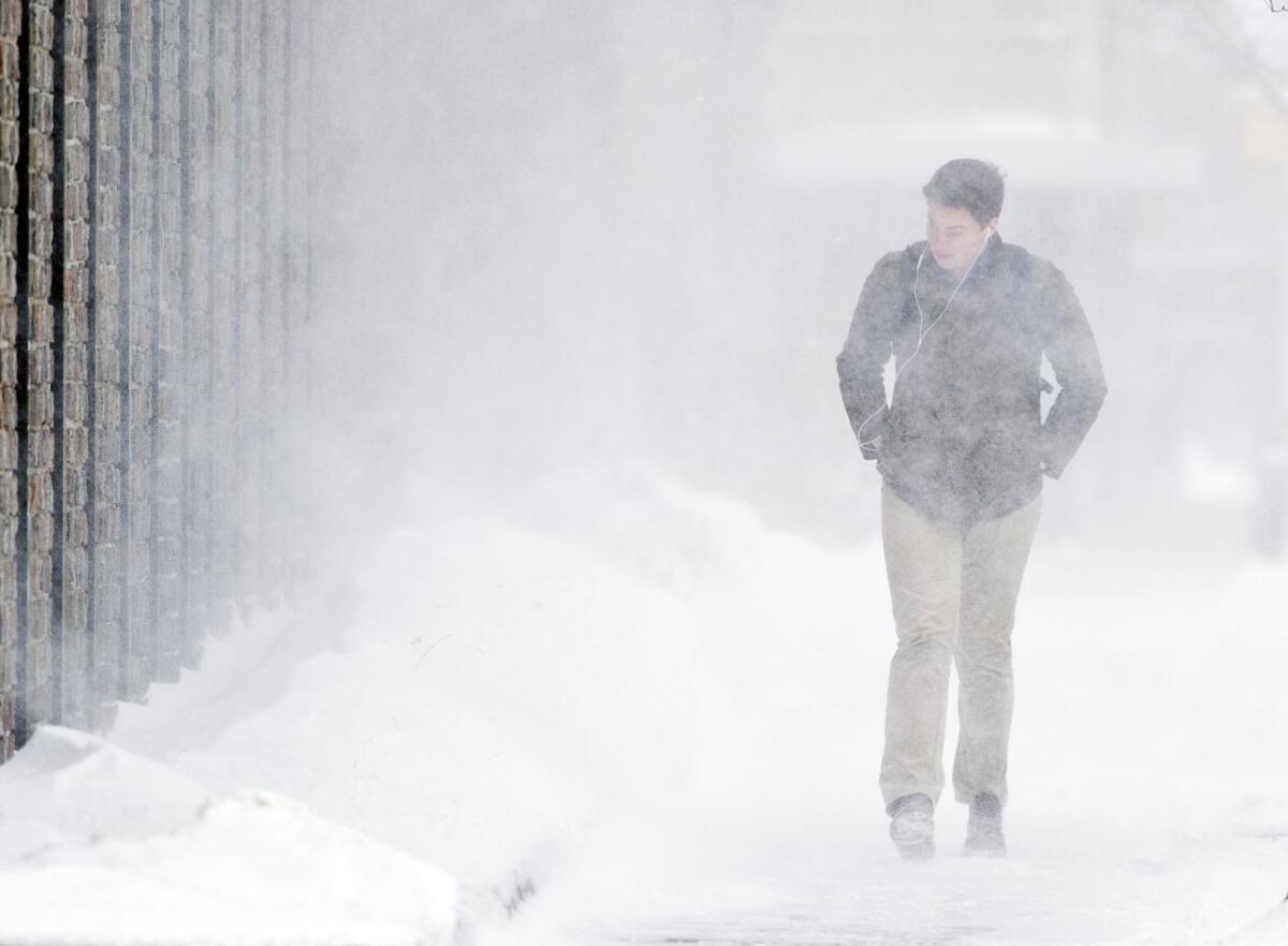 Gannon University junior Sean Hupp, 21, of Beaver Falls, Pa., walks through blowing snow in downtown Erie, Pa.