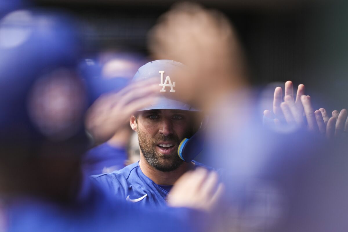 Chris Taylor celebrates in the dugout after scoring off of a double hit by Miguel Rojas.