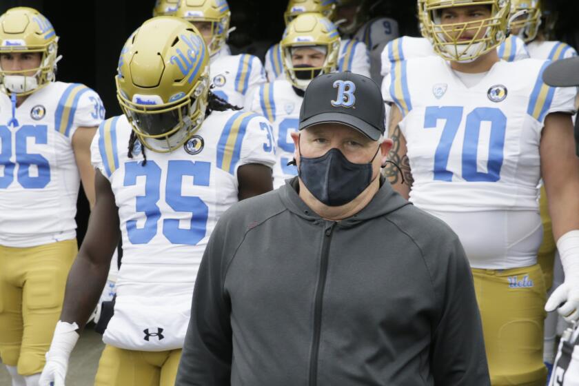 UCLA coach Chip Kelly leads his team on the field before its game against Oregon on Nov. 21, 2020, in Eugene, Ore.