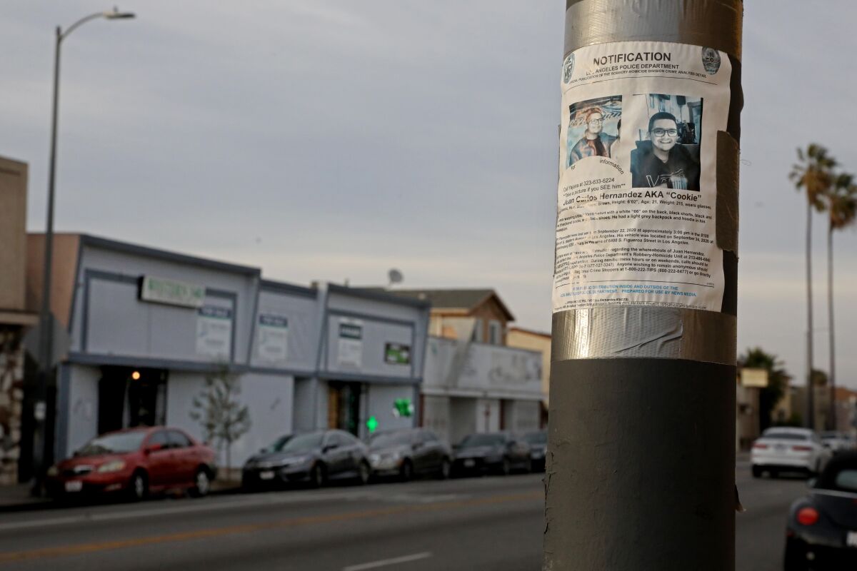 A missing persons flier on a street post.