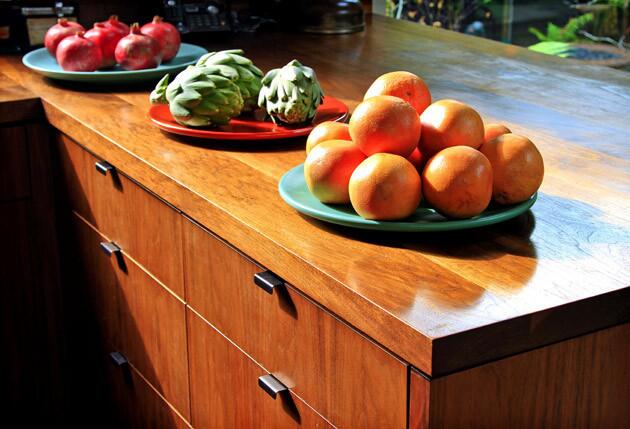 The kitchen cabinets and counters are made of walnut.