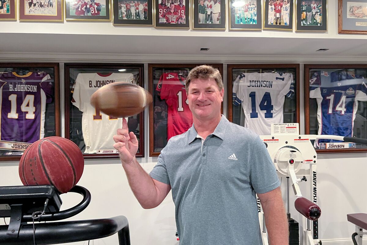Super Bowl-winning quarterback Brad Johnson spins a football on his finger inside his Athens, Ga., home.