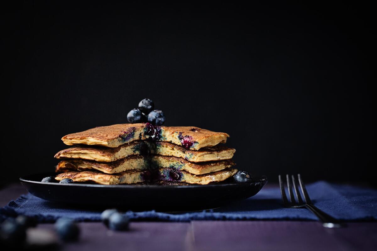 A plate of stacked blueberry pancakes.