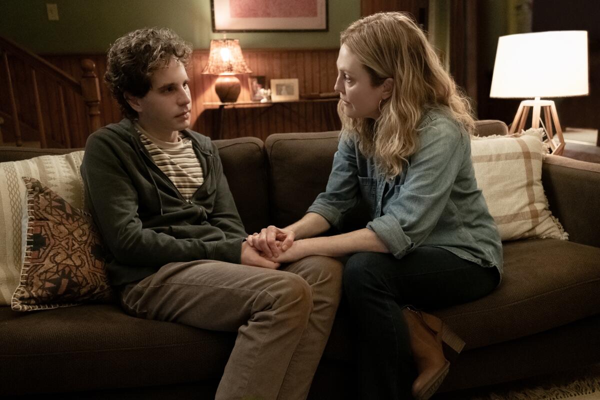 A young man and his mother sitting on a couch in the movie “Dear Evan Hansen”