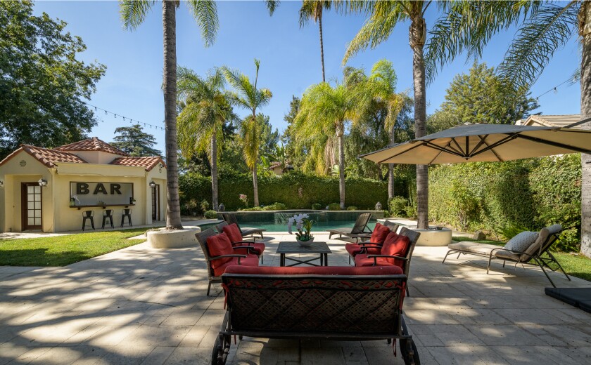 La retraite de l'amuseur comprend une cour arrière de style resort avec une piscine, un spa, un gazebo et un cabanon avec un bar.'s retreat includes a resort-style backyard with a pool, spa, gazebo and cabana with a bar.
