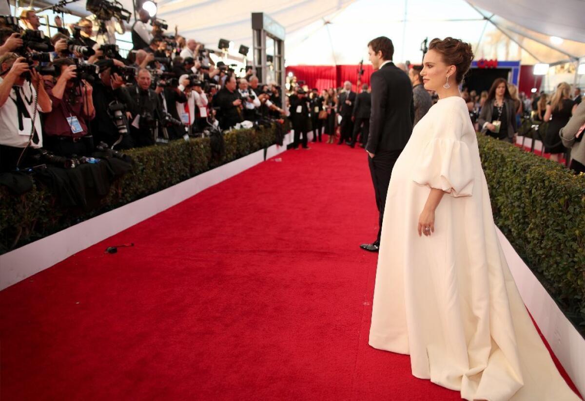 Natalie Portman walks the red carpet at this year's SAG Awards. She won't be attending the Oscars, citing her pregnancy.