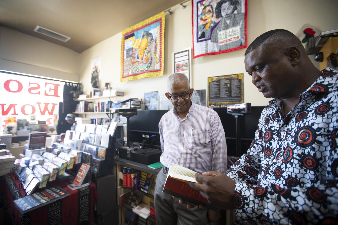 Co-Owner James Fugate of Eso Won Books, left, and Scot Brown, author of “Fighting for Us,” at the Leimert Park bookshop.