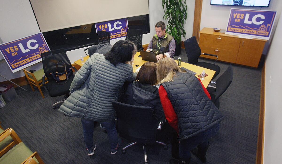 Telephone volunteers prepare to make phone calls to registered local voters of a Measure LC parcel tax at Compass Realty in La Cañada Flintridge on Jan. 16.